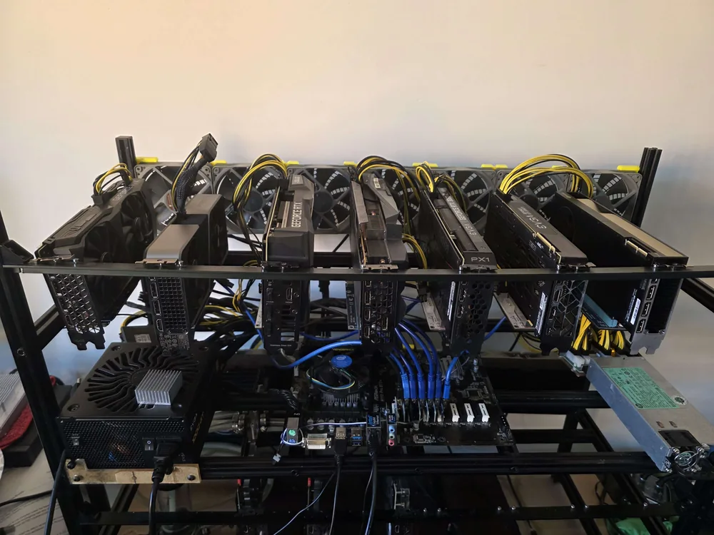 A DIY open-frame rig stacked with GPUs, cooling fans, and bundled cables
